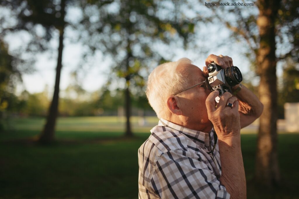 Personne âgée prenant une photographie dans la nature